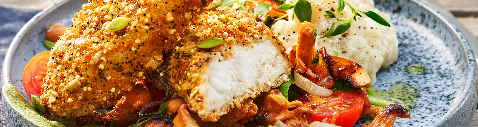 Panerad fisk med jordärtskocksmos, kantareller och spenat