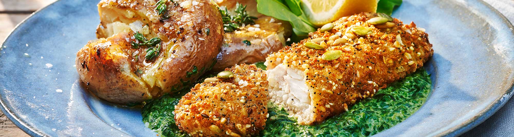 Panerad fisk med krossad potatis och stuvad spenat