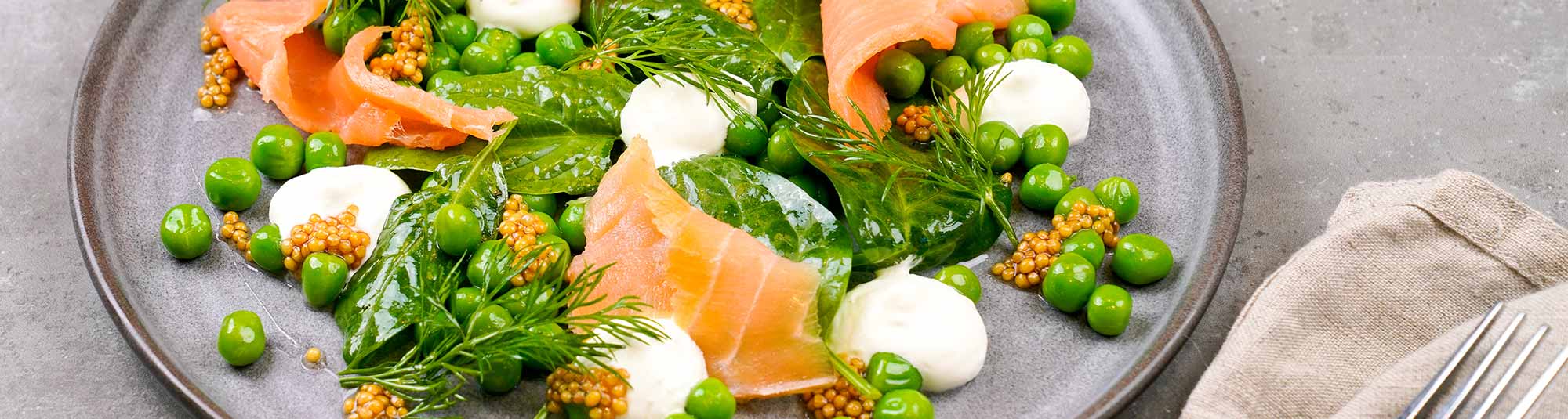 Ärtor med vispad pepparrotskräm, picklad senapsfrö och rökt lax 